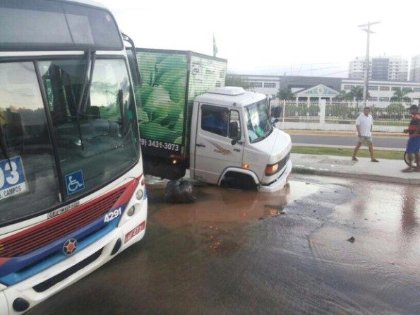 Ônibus e caminhão ficam presos em cratera após asfalto ceder em Aracaju