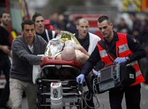   Uma pessoa ferida é socorrida após ataque ao escritório da revista satírica Charlie Hebdo, em Paris, em 7 de janeiro. (Foto: Thibault Camus / AP) 