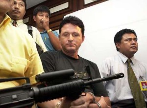  Guarda da polícia da Indonésia acompanha o brasileiro Marco Archer Cardoso Moreira durante uma coletiva de imprensa em Jakarta, em 20 de agosto de 2003.(Foto: Bay Ismoyo / AFP) 