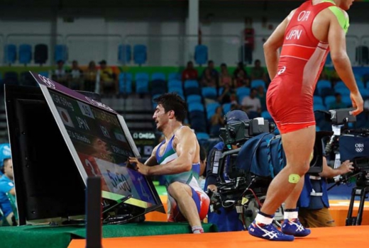 Iraniano derruba monitor ao ser empurrado por japonês durante confronto da luta olímpica (Foto: AFP/JACK GUEZ)