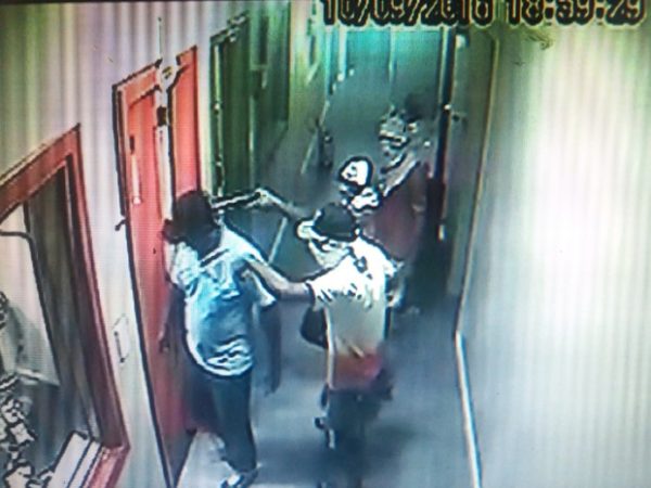 Na porta do estúdio, assaltantes apontam arma na cabeça do porteiro (Foto: Reprodução/TV Sergipe)