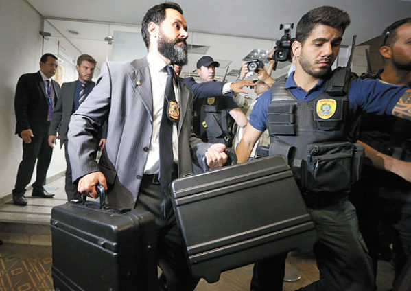 Policiais federais com material apreendido durante operação no Senado. (Foto: Pedro Ladeira/Folhapress)