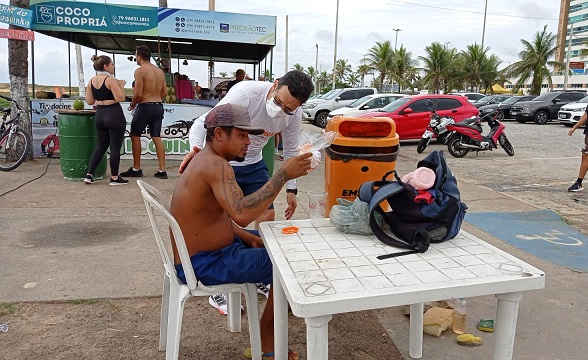 Ambulantes e população recebem orientações sobre exposição ao sol na praia de Atalaia em Aracaju