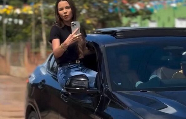 Prefeita de Umbaúba grava vídeo sentada na janela de carro de luxo em movimento para anunciar obras e gera polêmica